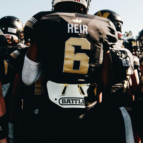 Football player wearing an adult Gold Chrome Battle Back Plate on the football field